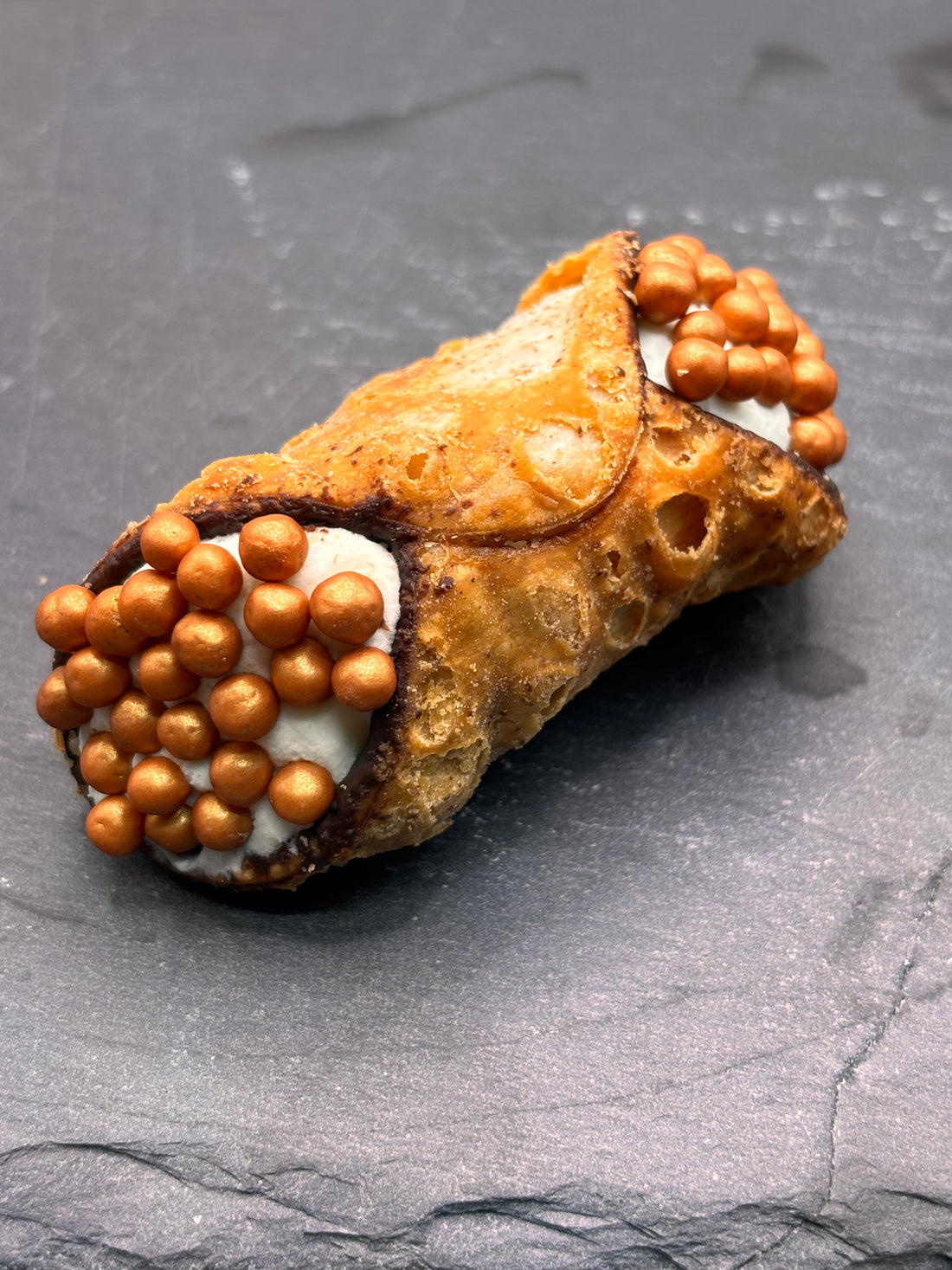 Een heerlijke Cannoli Champagne van Holy Cannoli, gevuld met romige champagne-vulling, perfect voor bij de koffie.