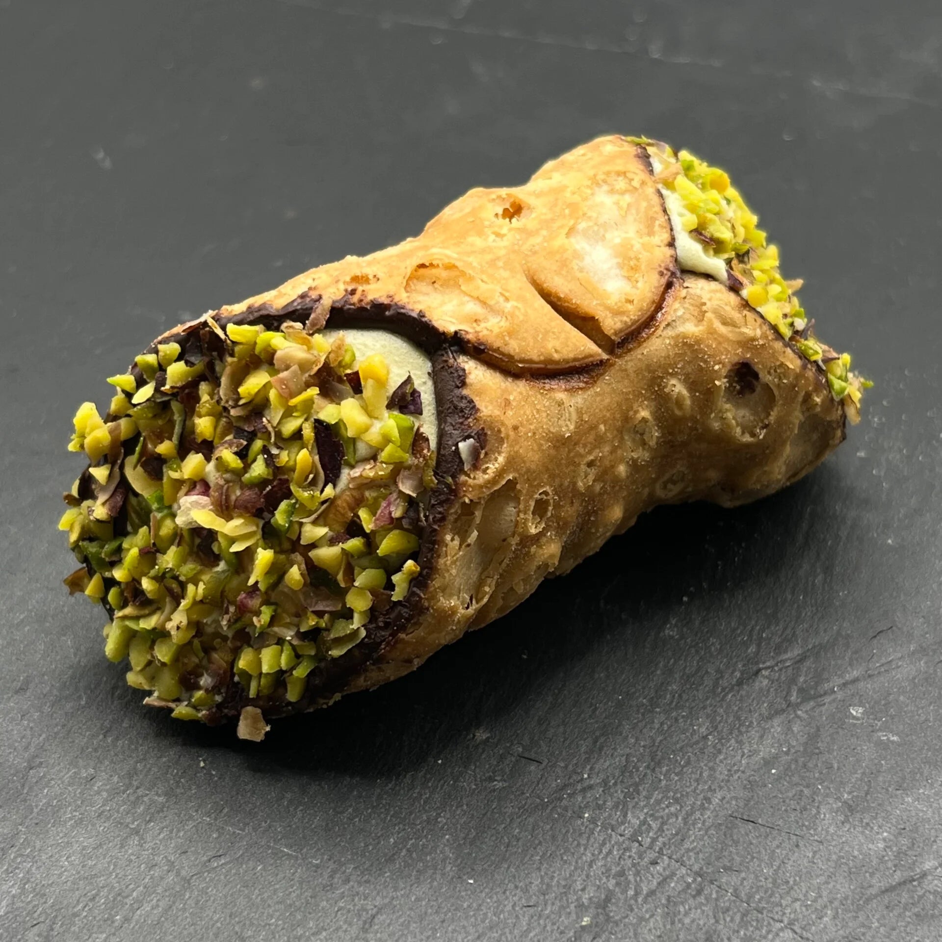 Een heerlijke Cannoli Pistacchio - Pistache met ambachtelijke pistache-vulling, perfect als traktatie bij een kopje koffie. Geniet van de authentieke Italiaanse smaak!